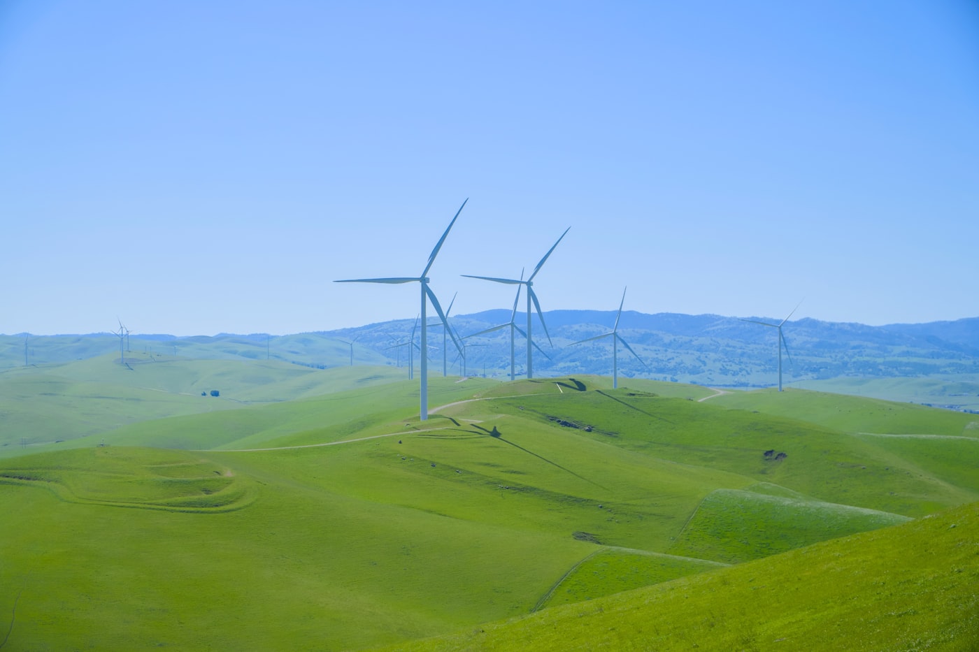 Windräder auf grünen Hügeln